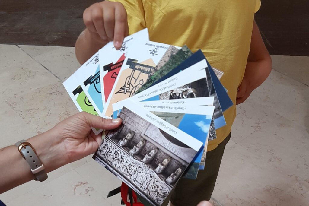 un bambino sceglie una cartolina dal mazzo