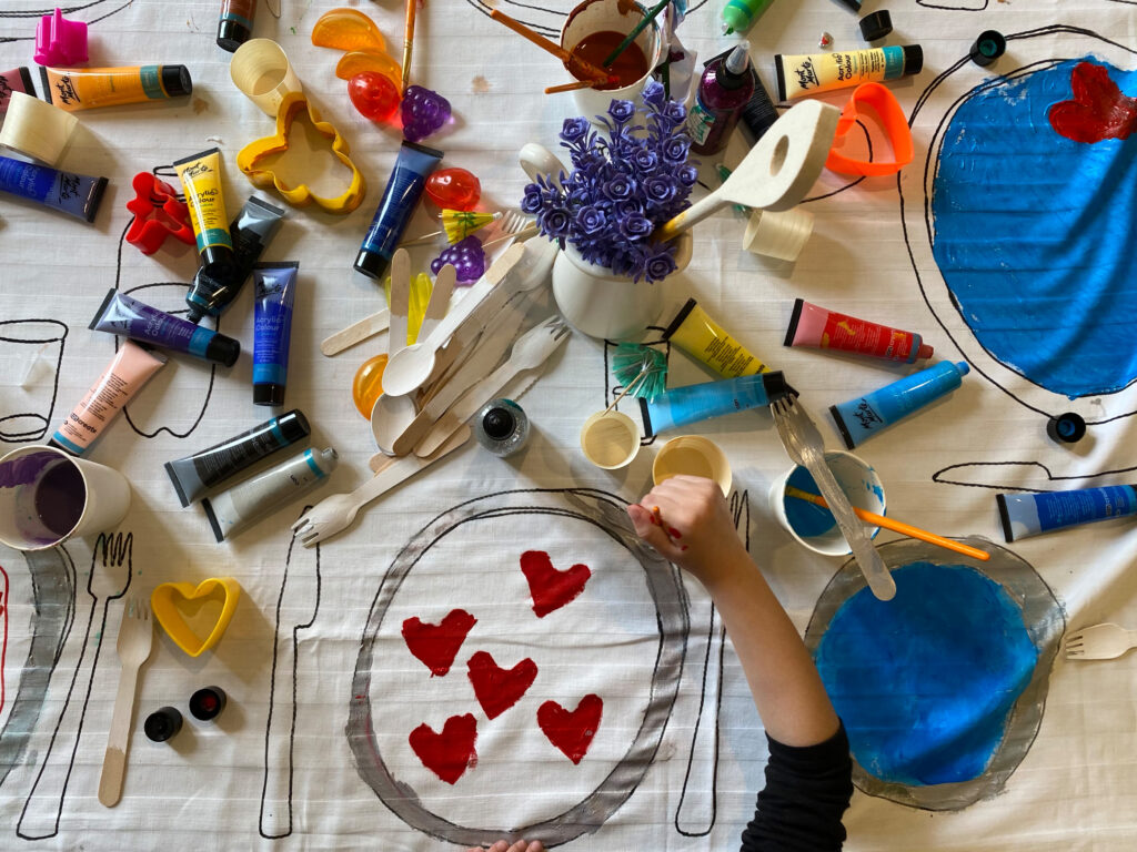 Un bambino dipinge la stoffa con le tempere
