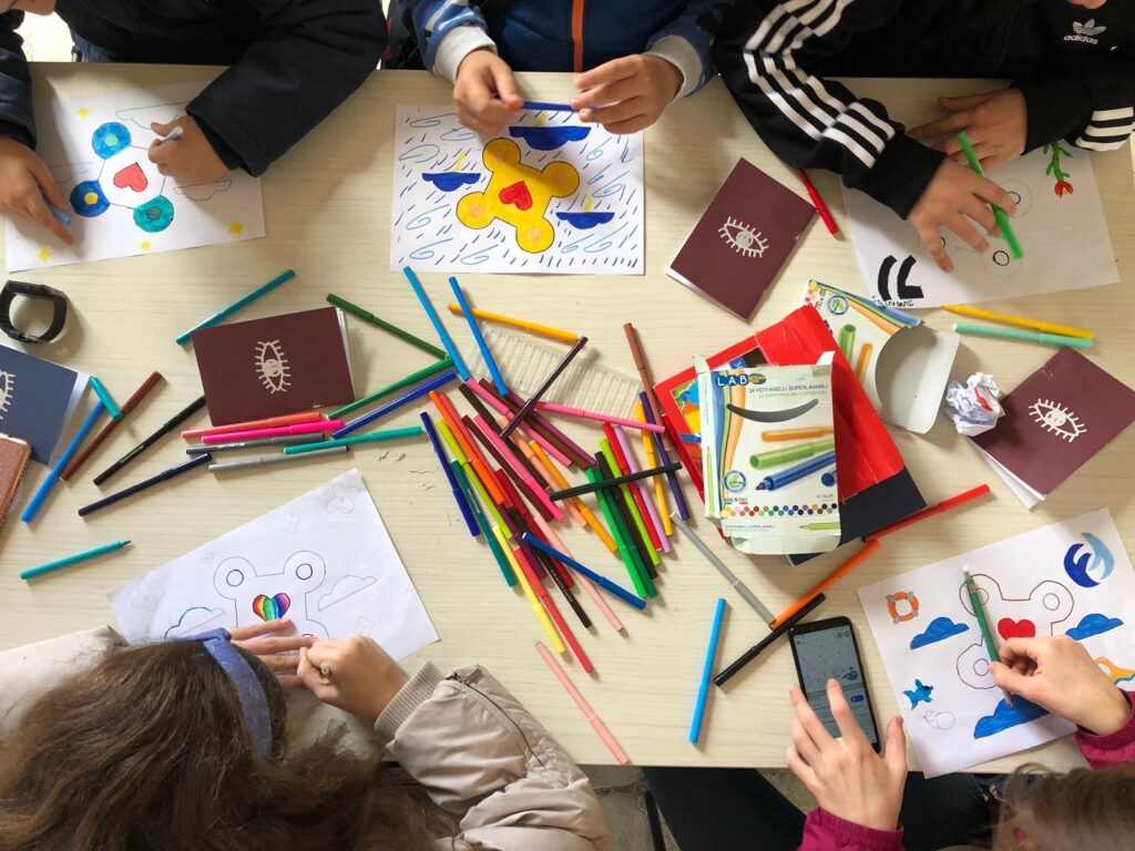 Bambini che colorano attorno al tavolo