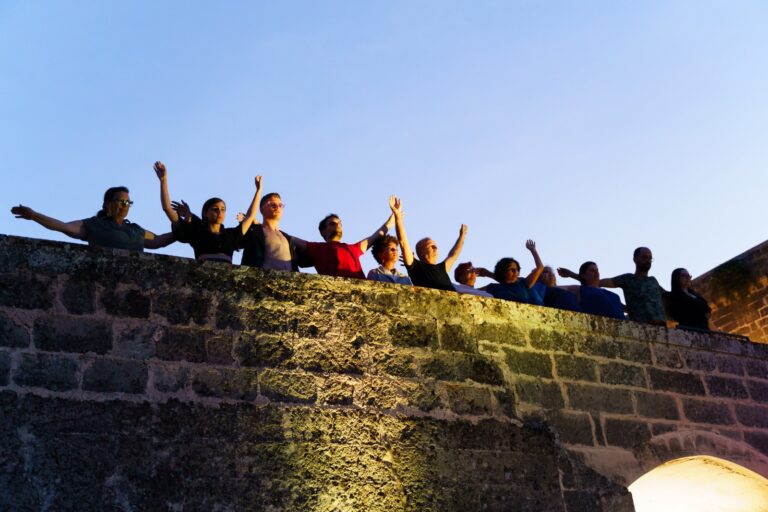 dodici partecipanti sulle terrazze del castello mentre mettono in scena la restituzione del laboratorio Frantumare le distanze