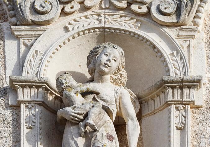 Statua della carità sulla facciata del castello De Monti di Corigliano