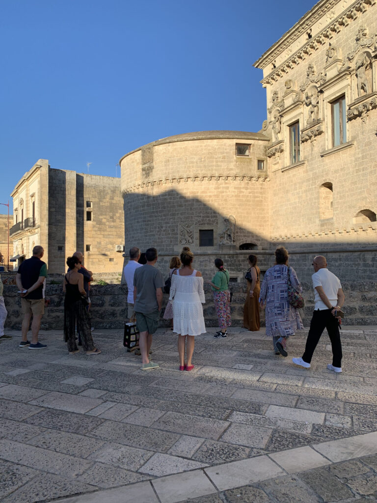 visitatori durante una visita guidata di fronte la facciata del castello